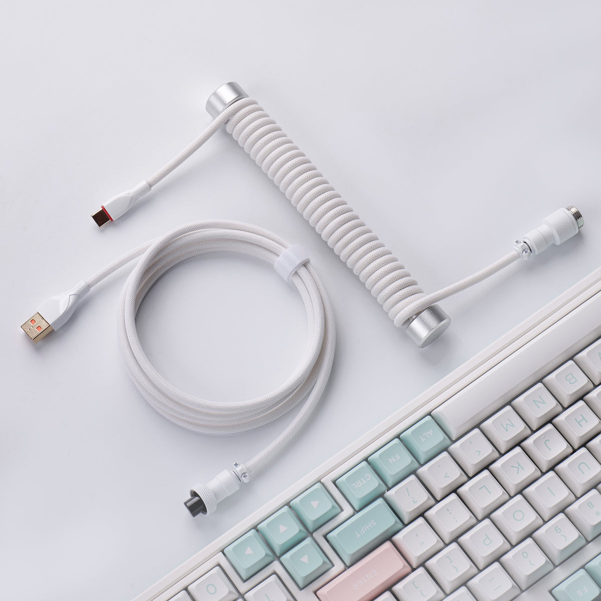 White aviator keyboard cable with silver weighted guide bar on a desk